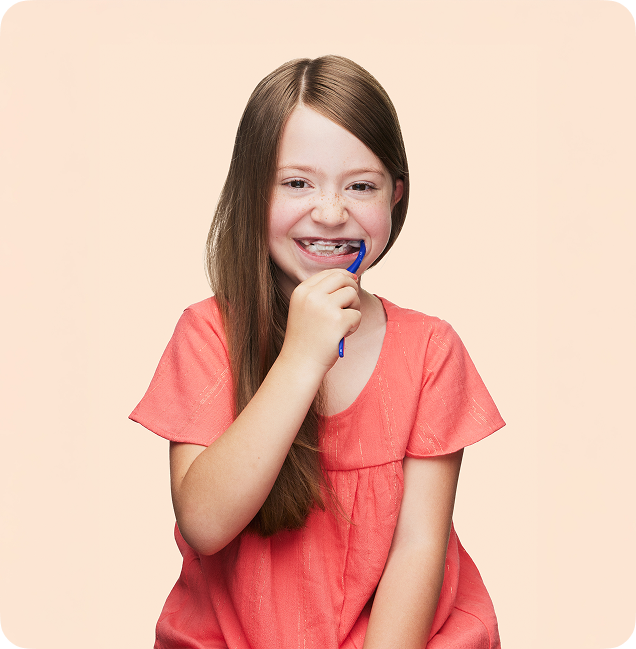 young girl wearing braces brushing her teeth