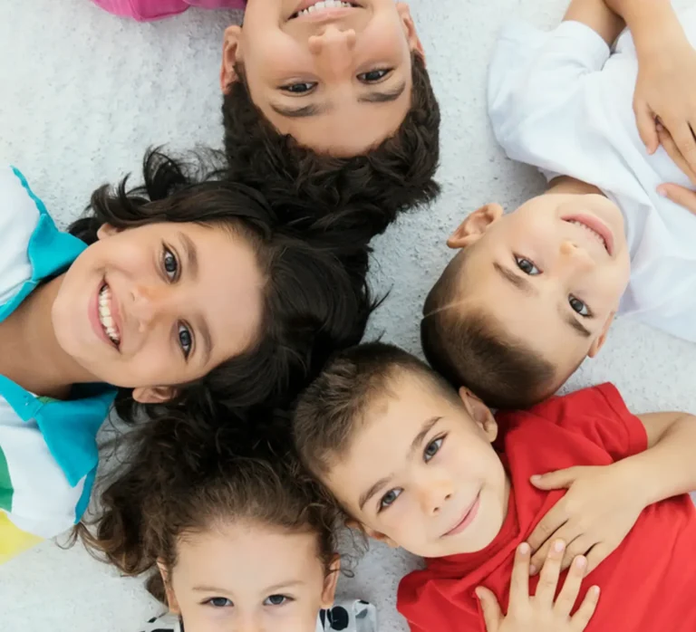 a group of happy kids on the floor looking up