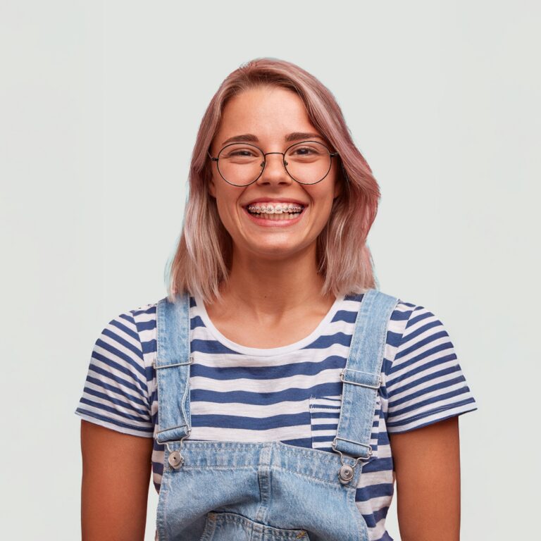 a teenage girl with braces wearing overhauls
