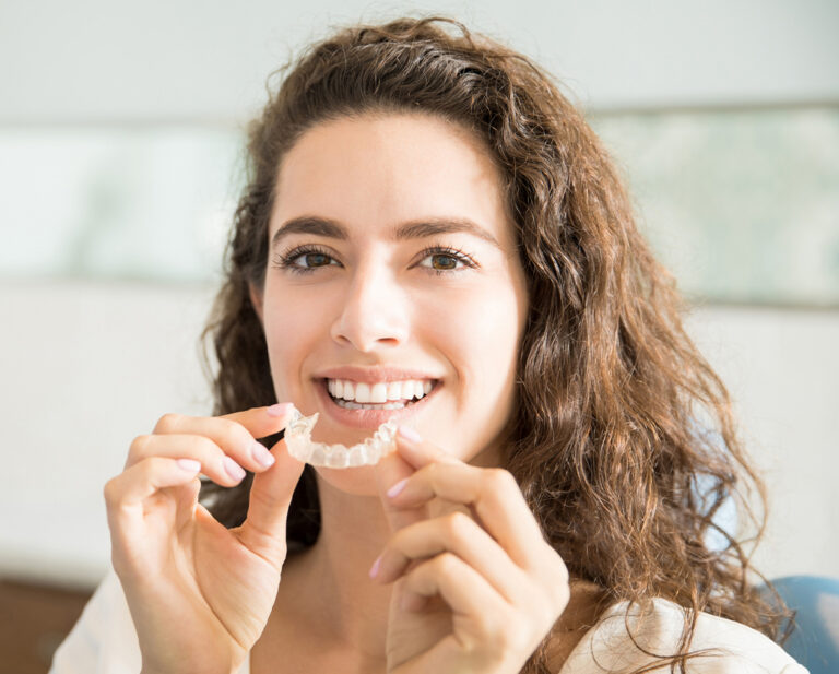 Woman Inserting Clear Smiling Retainer