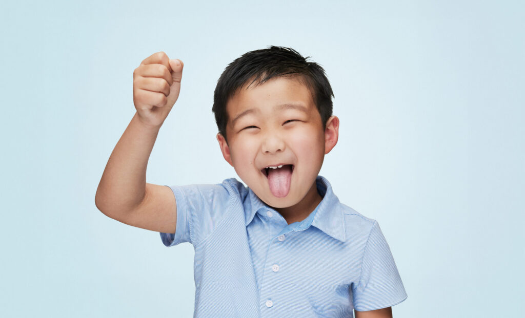 A Young Boy Wearing A Blue T Shirt Making A Silly Happy Face