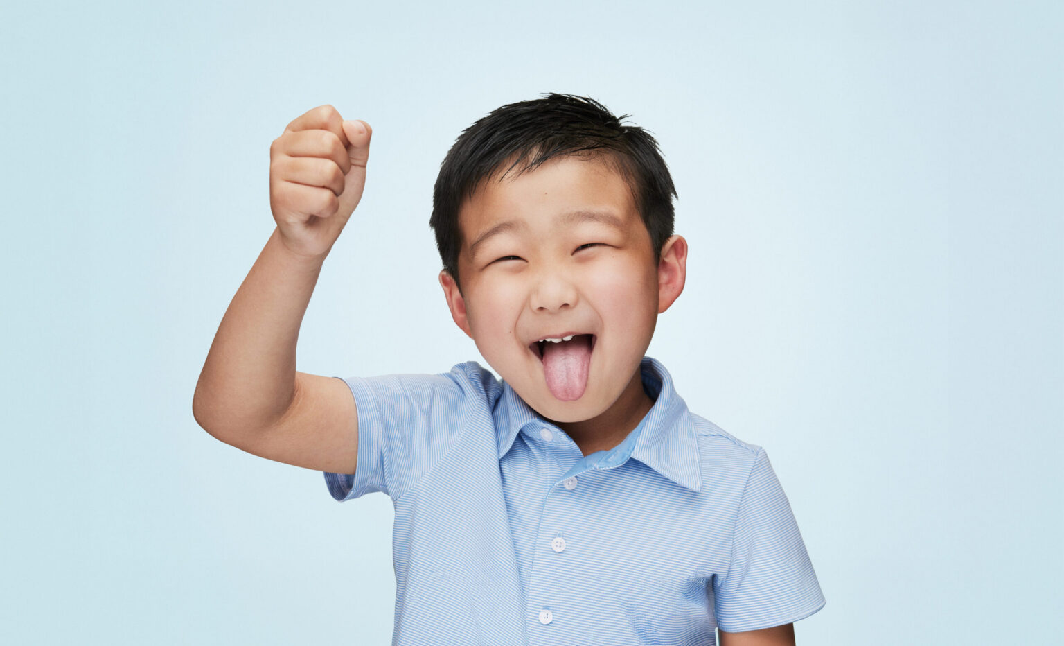 A Young Boy Wearing A Blue T Shirt Making A Silly Happy Face